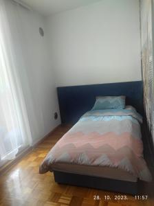 a bedroom with a bed with a blue and pink comforter at Azer in Sarajevo
