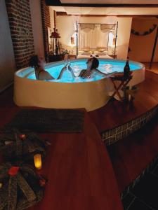 two people in a bath tub in a room at Baiser de Cupidon in Verviers