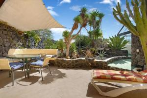 a patio with a table and chairs and a pool at Casa Verde in Teguise