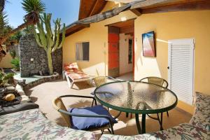 a patio with a glass table and chairs on a patio at Casa Verde in Teguise