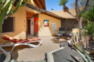 a patio with a tv and a table and chairs at Casa Verde in Teguise