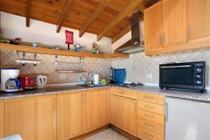 a kitchen with wooden cabinets and a black microwave at Casa Verde in Teguise