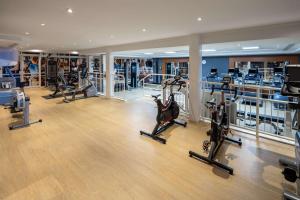 a gym with several treadmills and elliptical machines at Hilton Northampton Hotel in Northampton