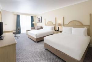 a hotel room with two beds and a television at Hilton Northampton Hotel in Northampton