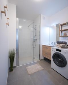 a bathroom with a shower and a washing machine at Cosy, lumineux, proche du centre-ville in Caen