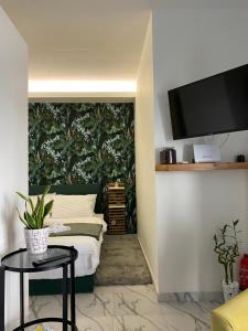 a bedroom with a bed and a tv on a wall at ΑΘΗΝΑ HOME in Ioannina