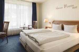 una habitación de hotel con una cama grande y una mesa en Sunderland Hotel, en Sundern