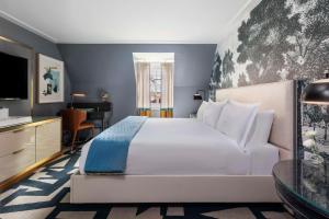 The Carolina Inn, a Destination by Hyatt Hotel في تشابل هيل: غرفة نوم مع سرير أبيض كبير ومكتب