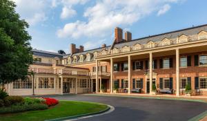 un grand bâtiment en briques avec une allée circulaire dans l'établissement The Carolina Inn, a Destination by Hyatt Hotel, à Chapel Hill