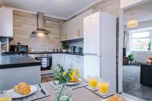 a kitchen with a table with two glasses of orange juice at Cozy Three Bedroom House Near City Centre with Free Parking in York