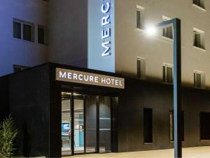 ein Schild für ein meereres Hotel vor einem Gebäude in der Unterkunft Mercure Toulouse Aeroport Blagnac in Blagnac