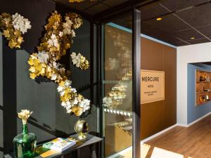 Mercure Toulouse Aeroport Blagnac في بلانياك: غرفة مع إناء من الزهور على الحائط