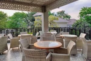 a patio with chairs and tables and a fence at Ramada by Wyndham Yogyakarta in Yogyakarta