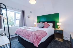 a bedroom with a large bed with a green headboard at Cozy Three Bedroom House Near City Centre with Free Parking in York