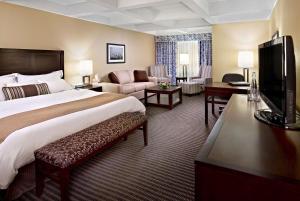 um quarto de hotel com uma cama grande e uma sala de estar em Wyndham Edmonton Hotel and Conference Centre em Edmonton