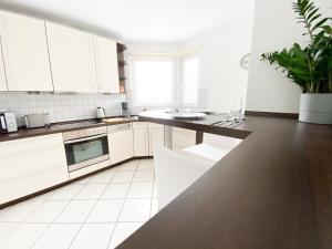 een keuken met witte kasten en een zwart aanrecht bij 1-4 Pers. Moderne 2-Etagen-Wohnung - nur 0,3 km vom Zentrum in Remscheid