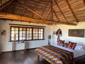 1 dormitorio con cama y techo de madera en umbila:Barra en Inhambane