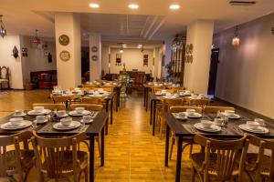 a dining room with tables and chairs with cups and plates at Antika Amman Hotel in Amman