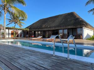 a resort with a swimming pool and a hut at umbila:Barra in Inhambane