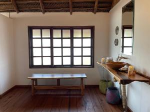 a room with a table and a sink and a window at umbila:Barra in Inhambane