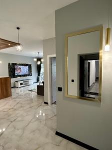 ein Wohnzimmer mit einem großen Spiegel an der Wand in der Unterkunft Premium Exclusive Suite in Nowy Dwór Mazowiecki