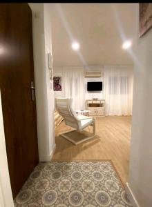 a living room with a chair and a television at Apartamento Triana in Seville