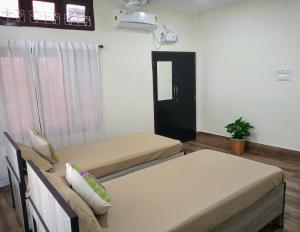 a room with two beds and a window at Globetrotters homestay in Jorhāt