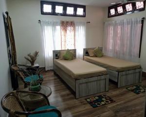 a living room with two beds and a window at Globetrotters homestay in Jorhāt