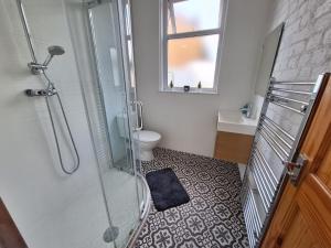 Modern ground floor flat - 15 min to Central London في لندن: حمام مع دش ومرحاض ومغسلة