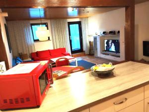 cocina con sala de estar con microondas rojo en Ferienwohnung Jette, en Oestrich-Winkel