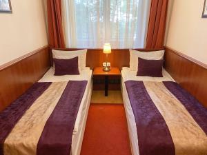 2 Betten in einem Zimmer mit einem Tisch und einem Fenster in der Unterkunft Gold Apartments in Budapest