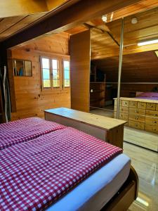 1 dormitorio con 1 cama en una cabaña de madera en Gemütliche FeWo mit Sauna inmitten der Berge, en Meiringen
