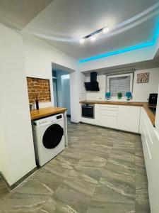 a kitchen with white cabinets and a stove at Bambuus Garden & Spa in Drăgăşani