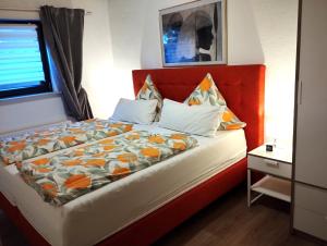 エーストリッヒ・ヴィンケルにあるFerienwohnung Jetteのベッドルーム1室(オレンジ色のヘッドボード付きのベッド1台付)