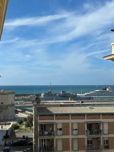 ein Gebäude mit Meerblick und einem Kreuzfahrtschiff in der Unterkunft Appartamenti Doria in Civitavecchia