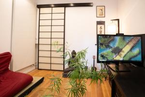 ein Wohnzimmer mit einem TV und einer Anlage in der Unterkunft L'Exotique - T2 Proche Paris & Bois de Vincennes in Saint-Mandé