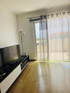 sala de estar con TV y ventana grande en Central Park Sea Views, en Santa Cruz
