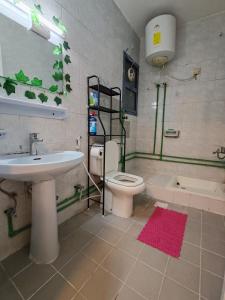 a bathroom with a sink and a toilet and a tub at Qamar home rental Deira in Dubai