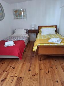 two beds in a room with wooden floors at Campo de Ourique Premium in Lisbon