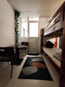ドバイにあるQamar home rental Deiraの二段ベッド、テーブル、デスクが備わる客室です。