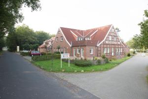 a large brick house with a sign in front of it at Hotel Restaurant Lathener Marsch in Lathen