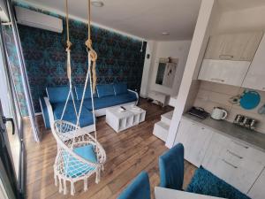 huśtawka w salonie z niebieską kanapą w obiekcie Apartman Ruzmići Divčibare w mieście Divčibare