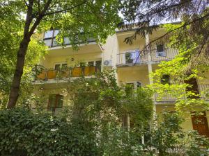 ブダペストにあるGold Apartmentsのバルコニーと木々のあるアパートメントビル