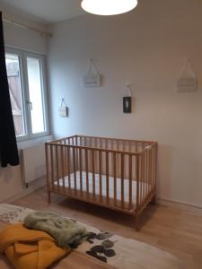 a nursery with a crib in a room with a window at maison village 3 chambres 30 minutes du zoo de beauval in Saint-Cyran-du-Jambot