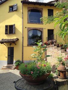 uma casa amarela com flores à frente em Altes Backhaus in Maranzana em Mombaruzzo