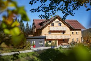 ein großes Backsteingebäude mit einem Dach in der Unterkunft Breitachhus in Riezlern