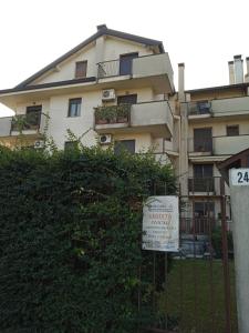 un panneau sur une clôture devant un bâtiment dans l'établissement Da Vale e Teo, à Legnano