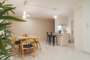 a dining room and kitchen with a table and chairs at Teega Muji 4BR 12 pax w bathtub by Our Stay in Nusajaya