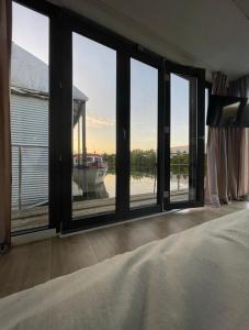 a bedroom with large windows with a view of a boat at 80qm privates Hausboot in Hamburg-Mitte in Hamburg