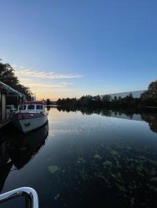 un barco está atracado en un río al atardecer en 80qm privates Hausboot in Hamburg-Mitte, en Hamburgo